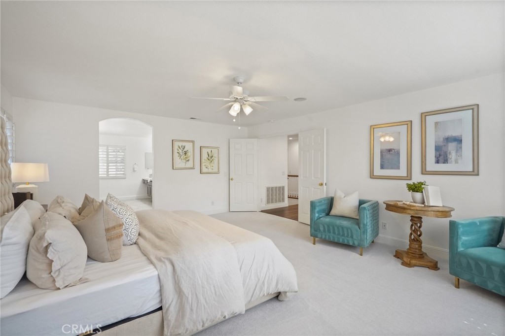 28 Rosenblum Irvine, CA 92602 - Photo 17 of 30 a spacious bedroom with a bed and a chandelier