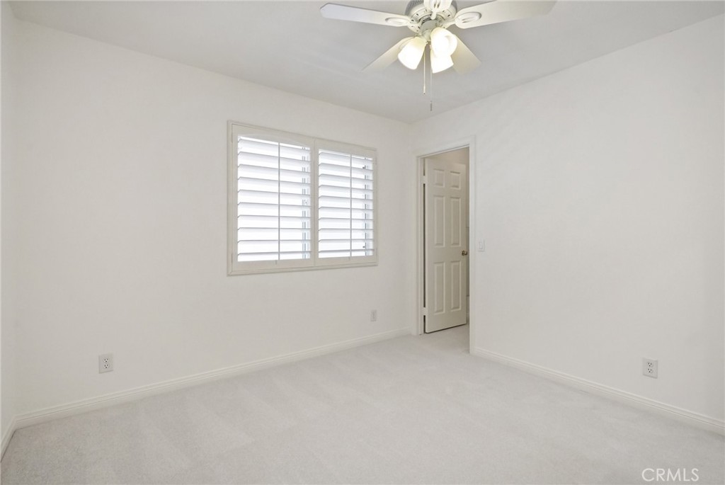 28 Rosenblum Irvine, CA 92602 - Photo 23 of 30 an empty room with a chandelier fan and windows