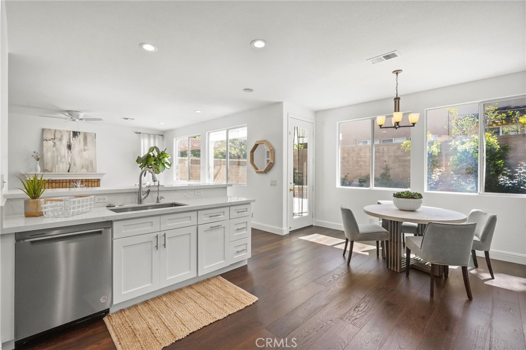 28 Rosenblum Irvine, CA 92602 - Photo 9 of 30 a dining room with wooden floor a chandelier a glass table and chairs