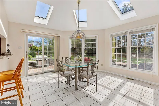 a dining room with furniture a chandelier and wooden floor