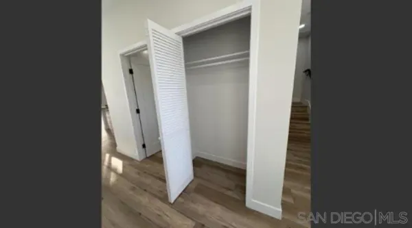 a view of a hallway with wooden floor and entryway