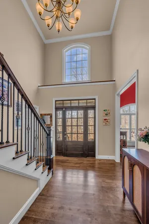 a view of a dining room with furniture a chandelier and wooden floor