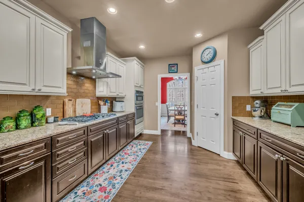 a kitchen with granite countertop a refrigerator and a stove top oven