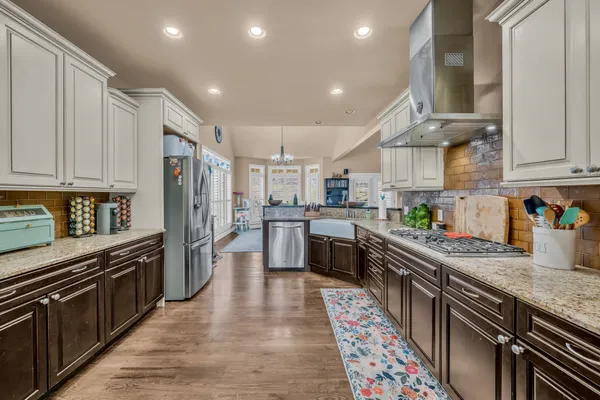 a kitchen with stainless steel appliances granite countertop a sink stove and refrigerator