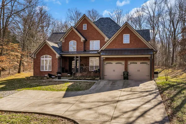 a view of a white house with a large yard and large tree