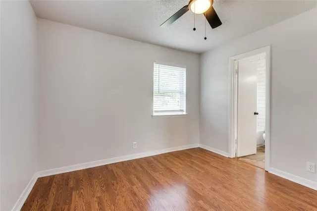 an empty room with a window and a ceiling fan