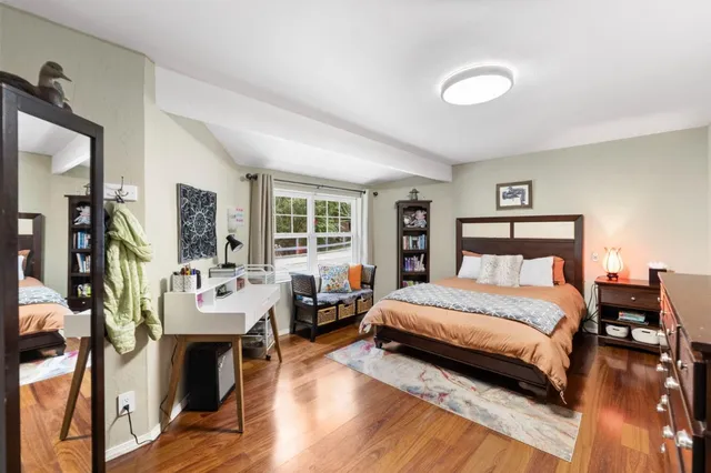 a bedroom with a bed and wooden floor