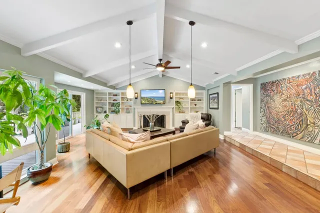 a living room with furniture fireplace and a large window