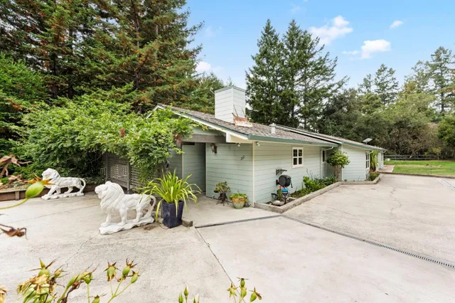 a view of a house with backyard and sitting area