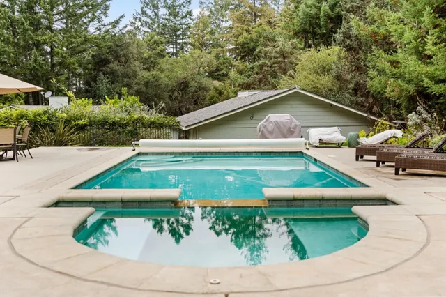 a view of backyard with swimming pool and outdoor seating