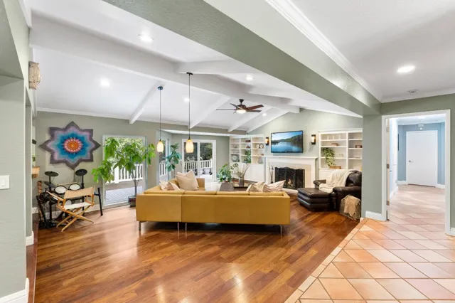 a living room with fireplace furniture and a large window