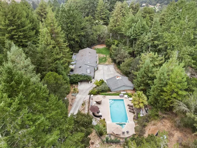 an aerial view of a house with a yard and trees