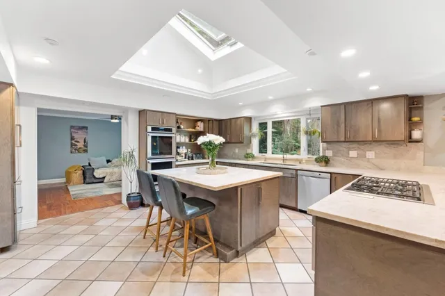 a kitchen island with a sink and chairs