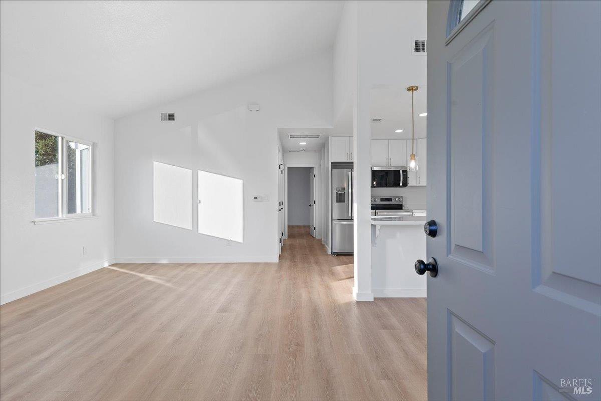 a view of empty room with wooden floor
