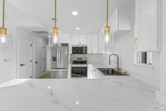 a kitchen with stainless steel appliances granite countertop a refrigerator and a sink