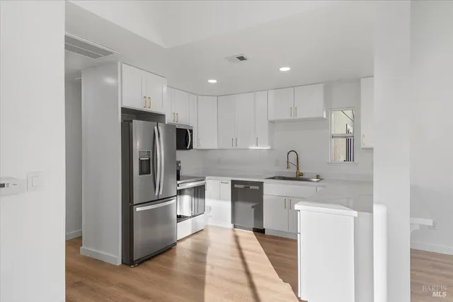 a kitchen with a refrigerator sink and cabinets