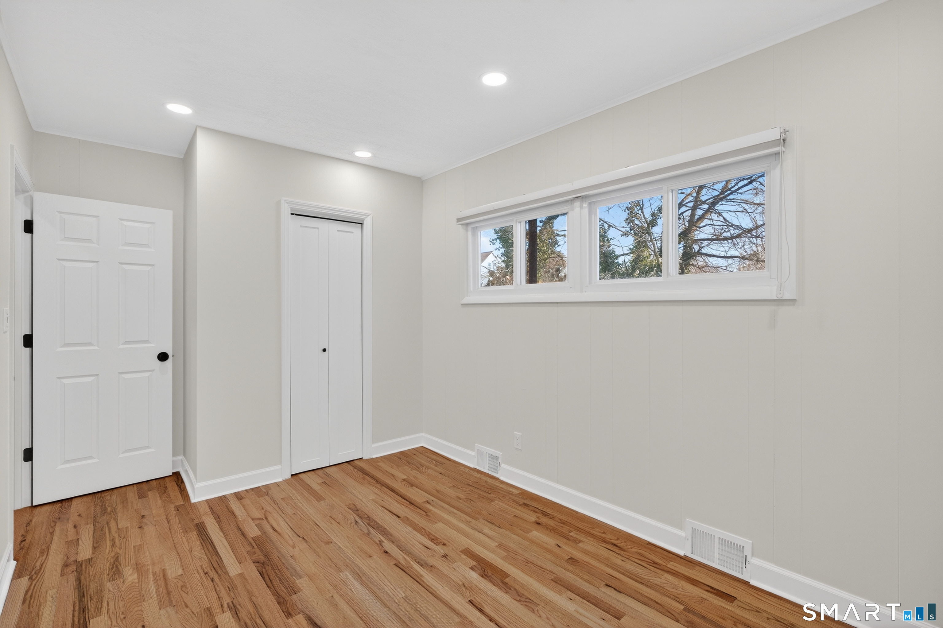 195 Laurel Place Bridgeport, CT 06604 - Photo 11 of 14 a view of an empty room with wooden floor and window