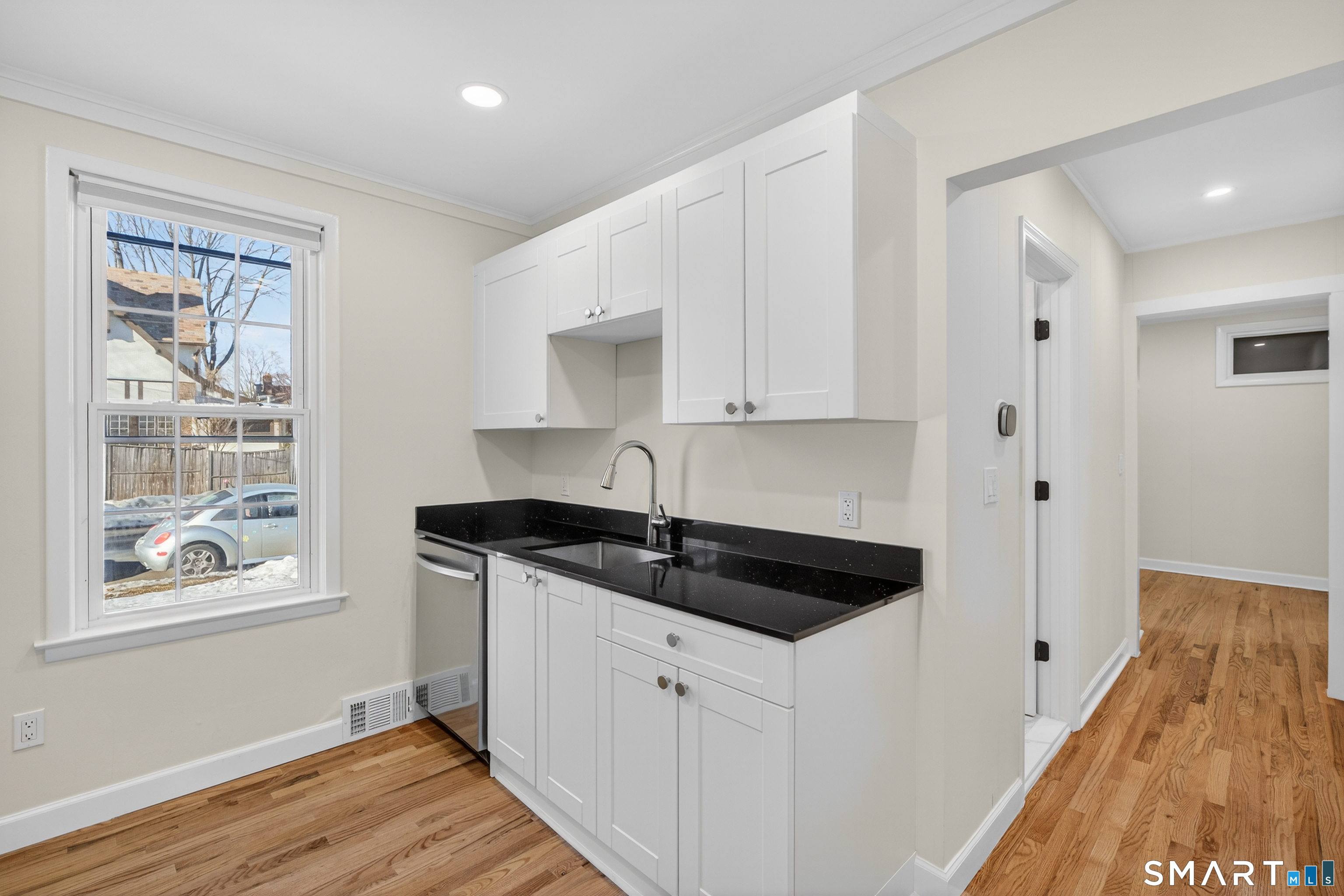 195 Laurel Place Bridgeport, CT 06604 - Photo 3 of 14 a kitchen with granite countertop white cabinets and a wooden floor