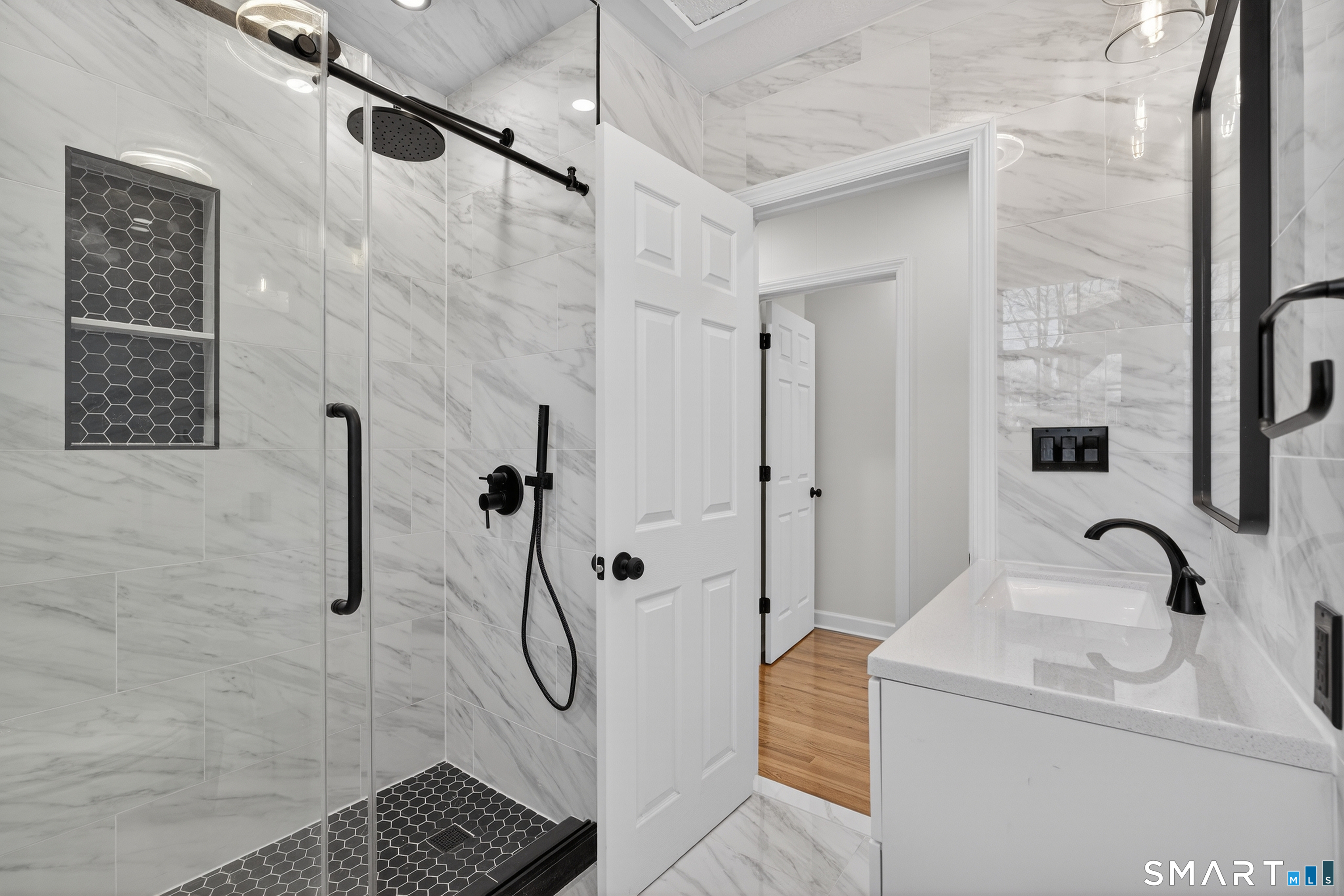 195 Laurel Place Bridgeport, CT 06604 - Photo 6 of 14 a bathroom with a sink a glass door shower and a mirror