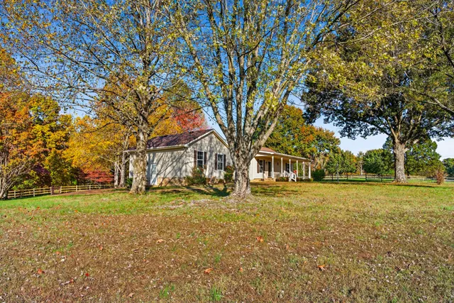 a big yard with trees in front of it