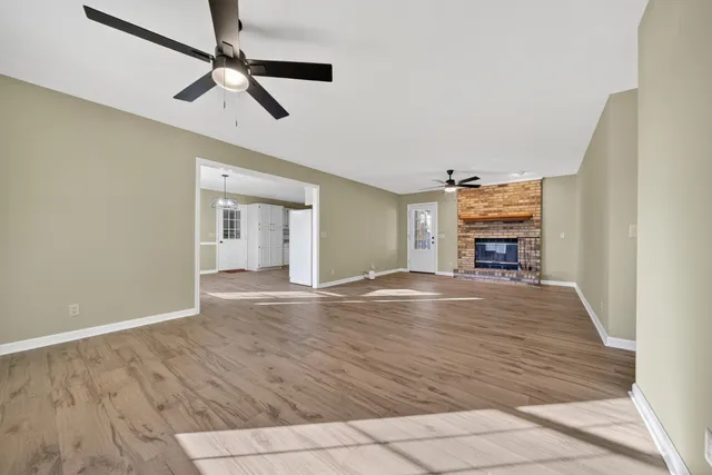 a view of empty room with wooden floor and fireplace