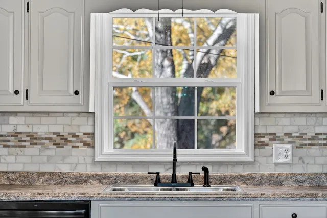 a kitchen with granite countertop white cabinets and stainless steel appliances
