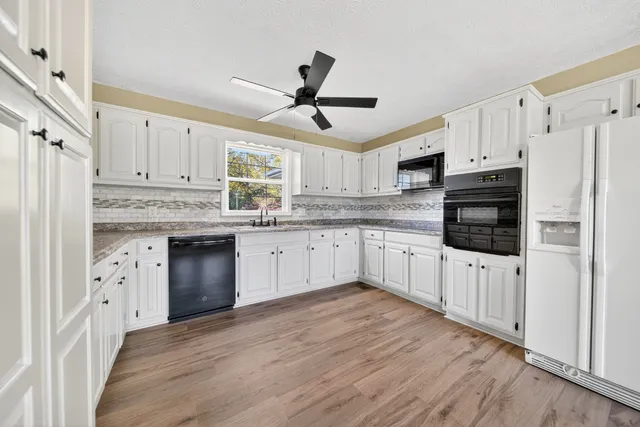 a kitchen with white cabinets and white appliances