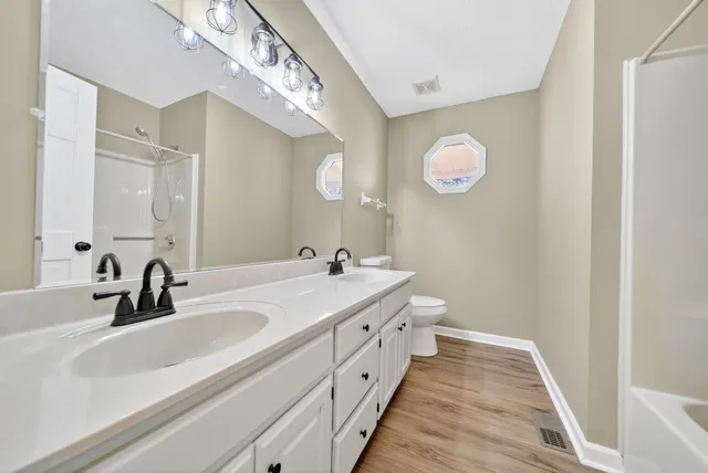 a view of a big room with wooden floor and windows