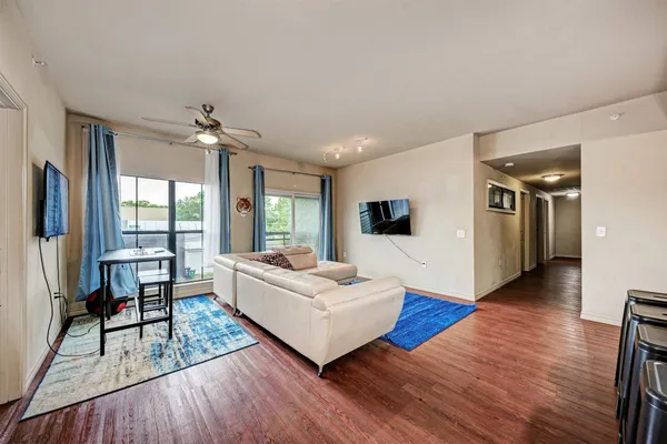 a living room with furniture and a wooden floor
