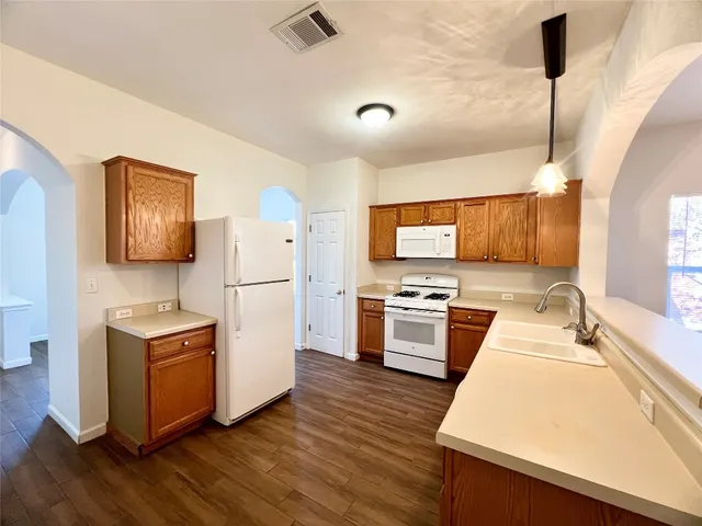 a kitchen with a refrigerator sink and wooden floor