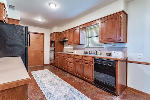 a kitchen with stainless steel appliances granite countertop a stove a sink and a refrigerator