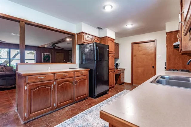 a kitchen with stainless steel appliances granite countertop a refrigerator a stove and a sink