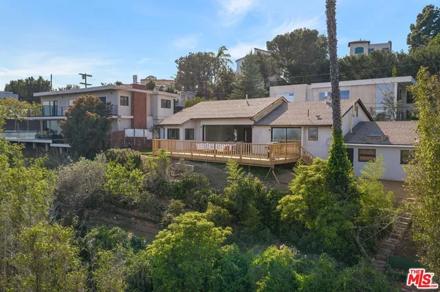a aerial view of a house with a yard and potted plants