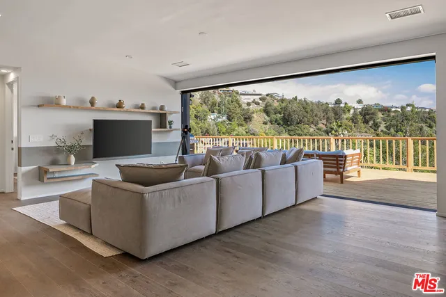 a living room with furniture a large window and a flat screen tv