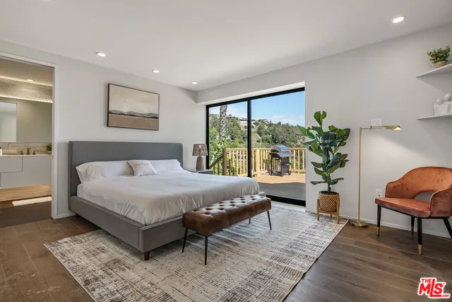 a bedroom with a large bed and a potted plant