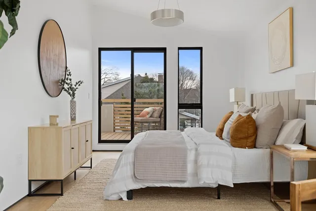 a living room with furniture a potted plant and a large window