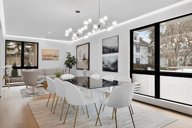 a dining room with furniture a large window and a chandelier