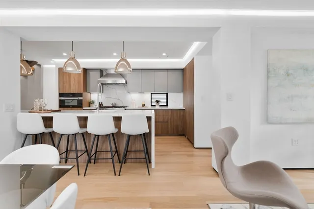 a dining hall with stainless steel appliances kitchen island granite countertop a dining table and chairs