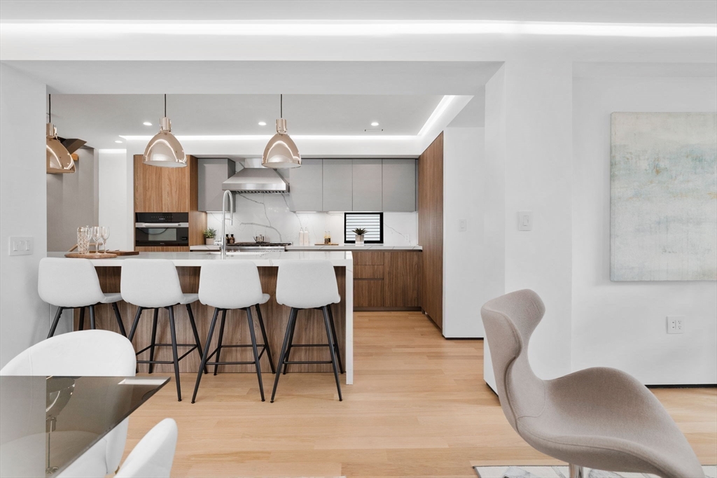 80 Alpine Street Cambridge, MA 02138 - Photo 10 of 41 a dining hall with stainless steel appliances kitchen island granite countertop a dining table and chairs