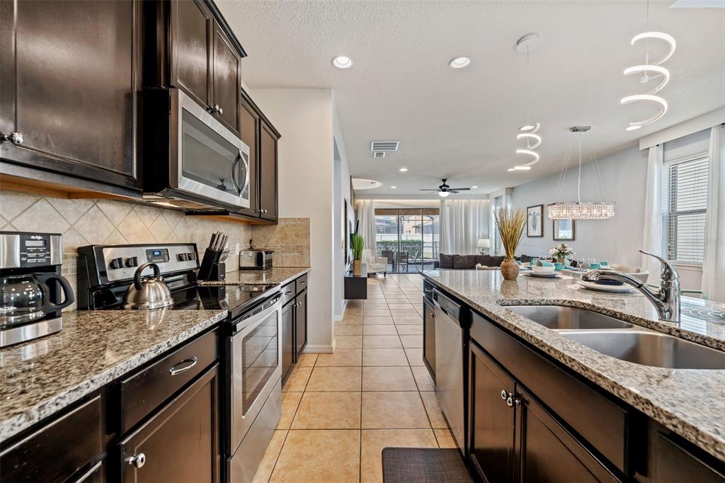 2108 Morocco Way Kissimmee, FL 34747 - Photo 22 of 57 a kitchen with granite countertop stainless steel appliances and sink