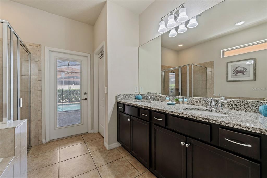 2108 Morocco Way Kissimmee, FL 34747 - Photo 34 of 57 a bathroom with a granite countertop sink a large mirror and a shower
