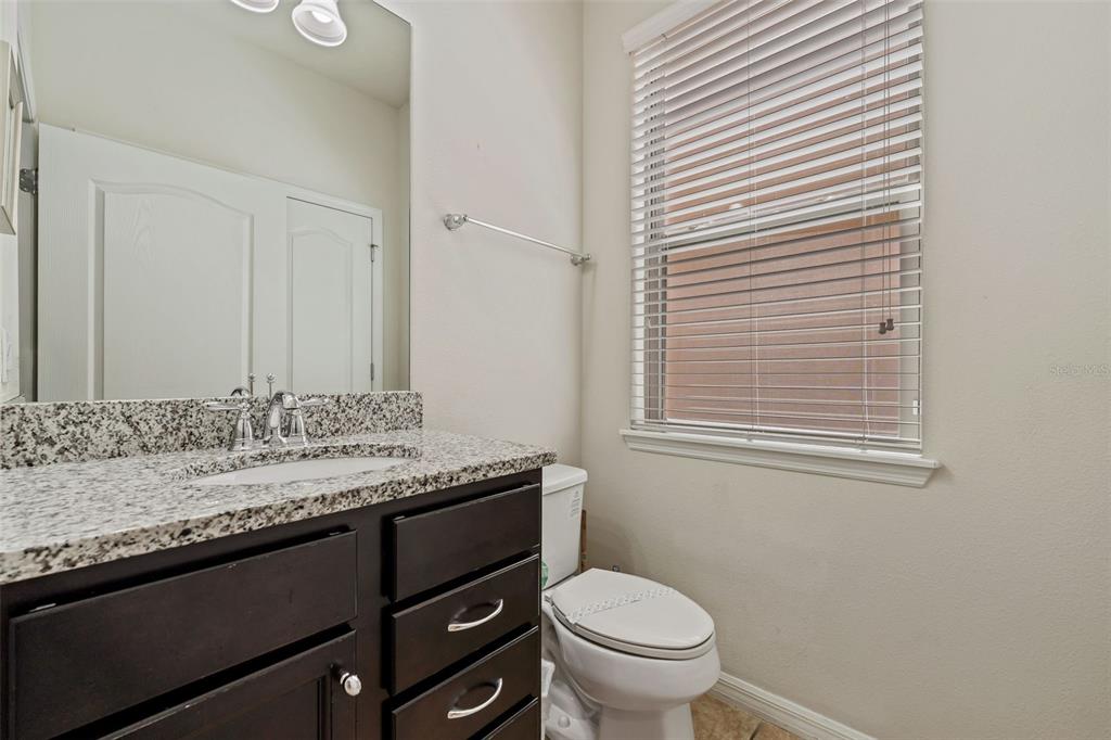 2108 Morocco Way Kissimmee, FL 34747 - Photo 36 of 57 a bathroom with a granite countertop sink toilet and mirror