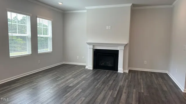 an empty room with wooden floor and fireplace