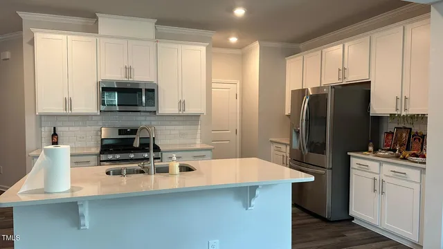 a kitchen with stainless steel appliances a refrigerator microwave and sink