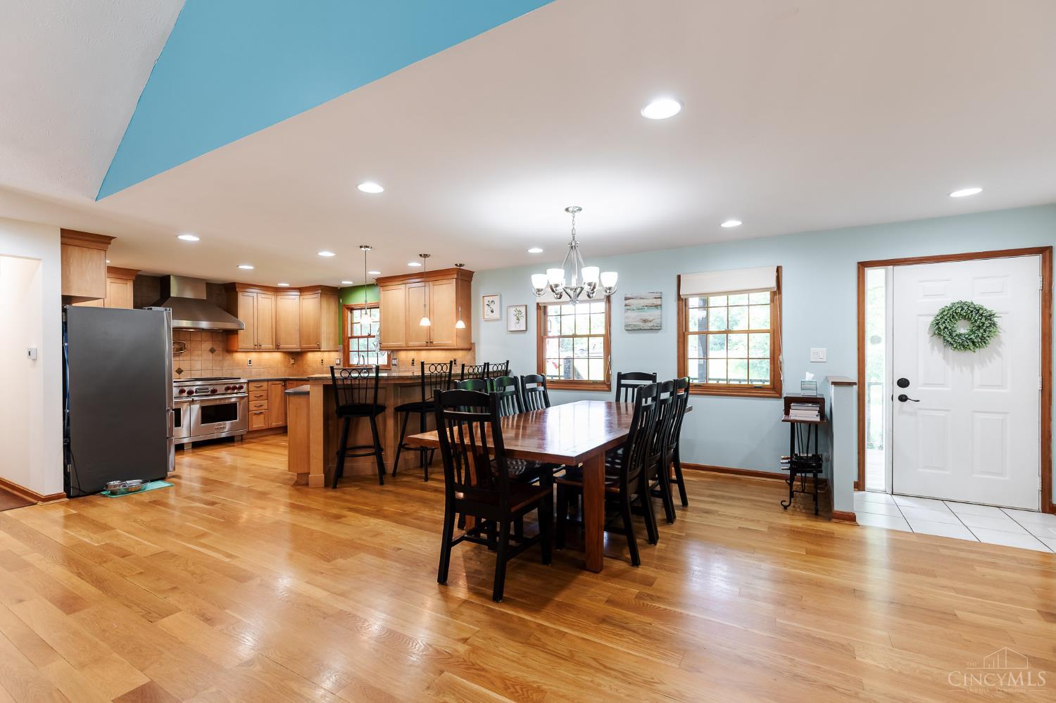 623 Ibold Road Loveland, OH 45140 - Photo 7 of 35 The dramatic great room features soaring vaulted ceilings with exposed beam accents, a cozy wood-burning fireplace, and expansive windows and walkout access to the deck via French doors that fill the space with natural light.