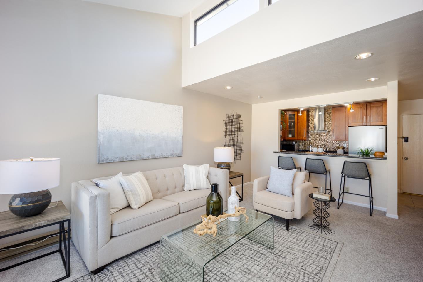 a living room with furniture and a view of kitchen