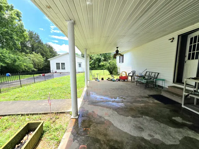 a view of swimming pool with a table and chairs in patio