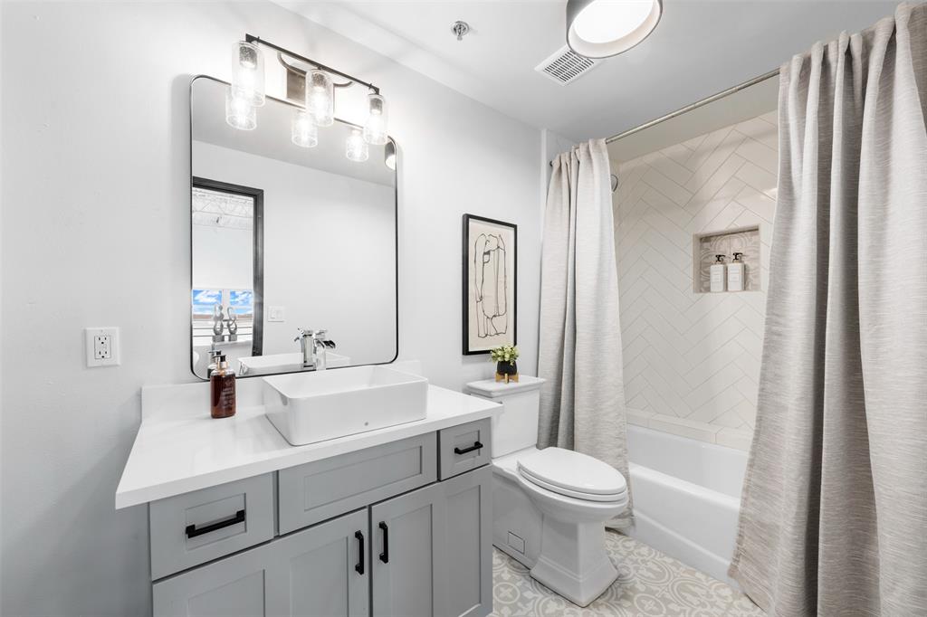 219 South 4th Street, Unit 608 Waco, TX 76701 - Photo 28 of 37 a bathroom with a sink a toilet a mirror and shower