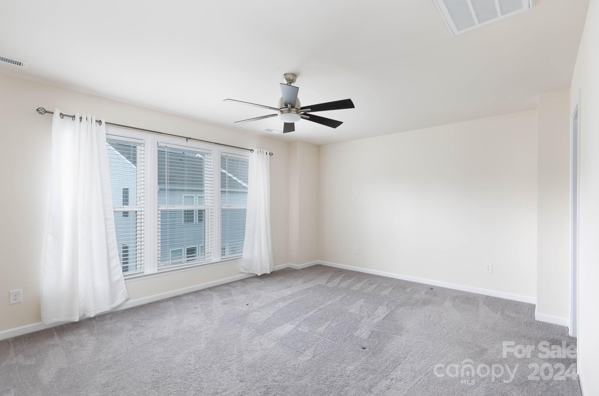 813 Canoe Song Road Fort Mill, SC 29708 - Photo 11 of 26 an empty room with a ceiling fan and windows