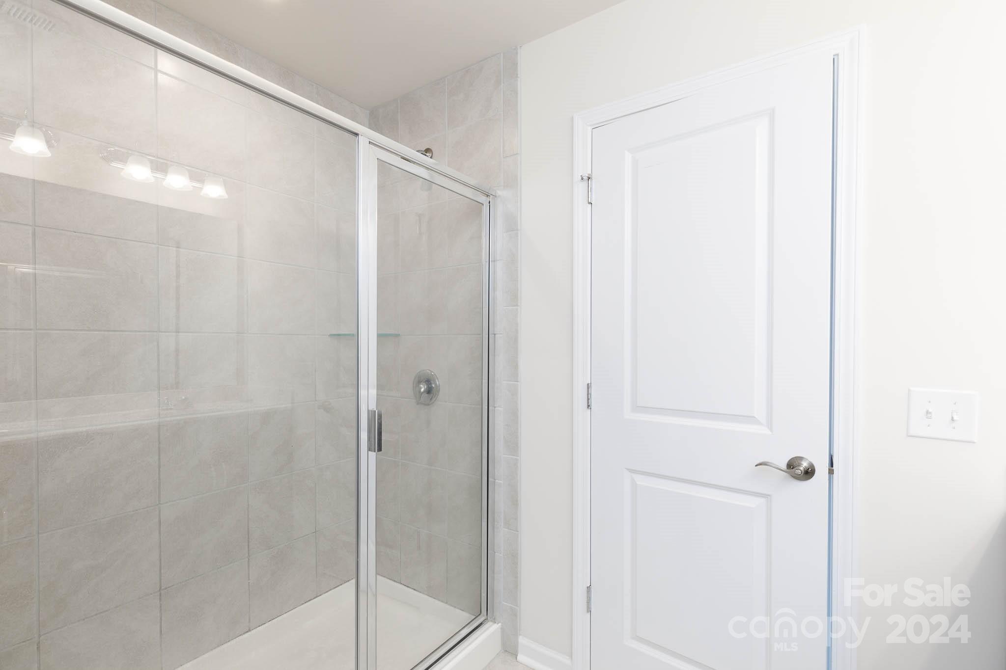 813 Canoe Song Road Fort Mill, SC 29708 - Photo 14 of 26 a bathroom with a glass shower door